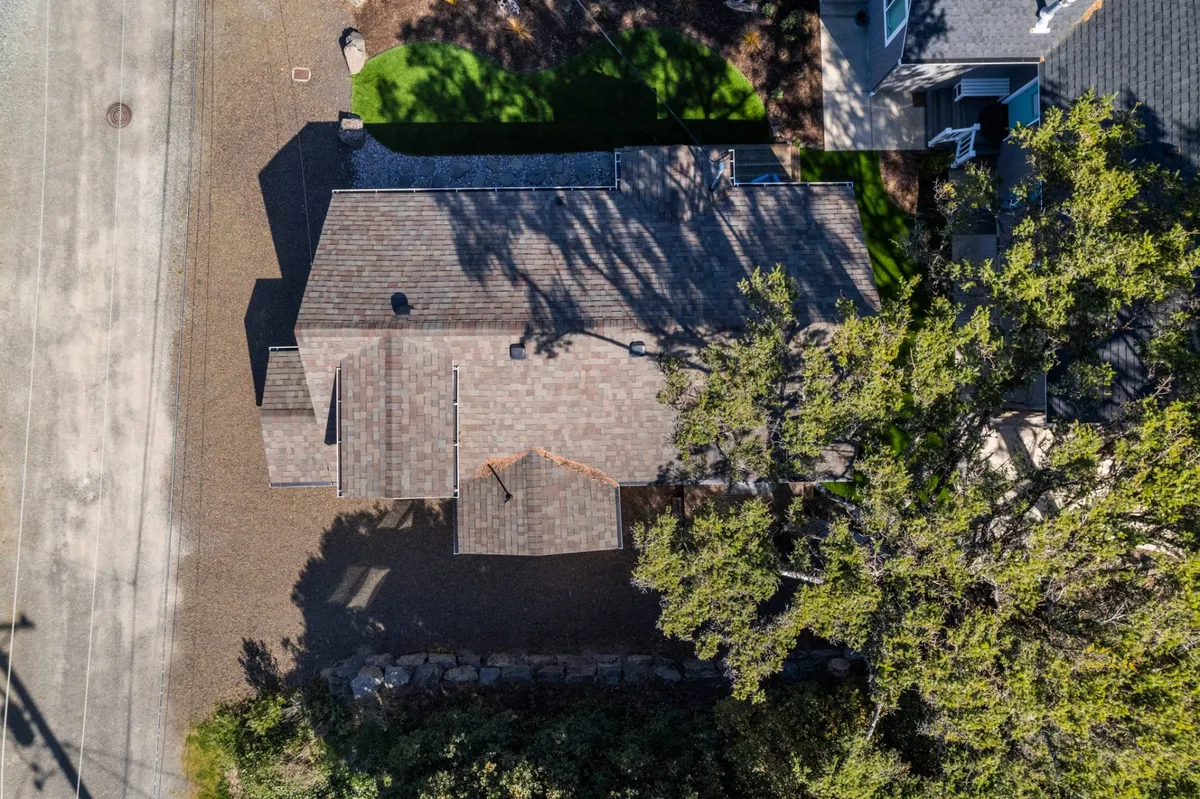 A peaceful exterior view with a landscaped area, roof texture, and surrounding trees. The outdoor setting suggests community gatherings and relaxation, evoking the spirit of shared seasonal activities and the picturesque setting where the railway passes.